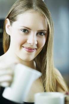 Portrait of a young woman holding a cup of tea