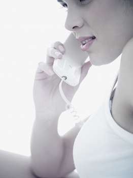 Side profile of a young woman using a telephone