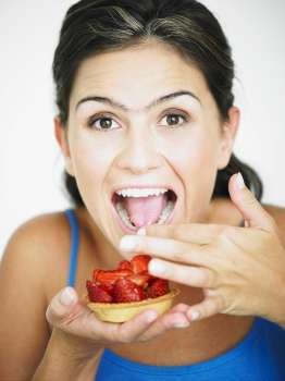 Portrait of a young woman eating strawberries