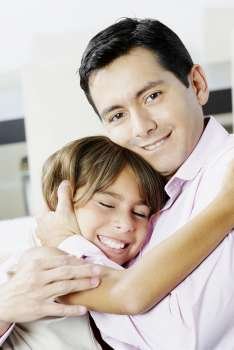 Portrait of a mid adult man hugging his daughter