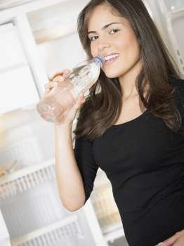 Portrait of a young woman drinking water from a bottle