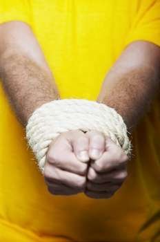 Close-up of a person´s hands tied together with a rope
