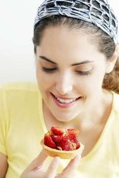 Close-up of a young woman looking at a strawberry tart