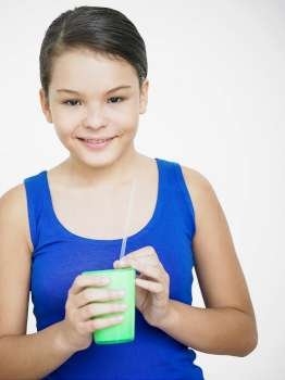 Portrait of a teenage girl holding a glass and smiling