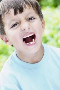 Close-up of a boy shouting while eating