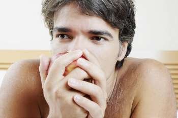 Close-up of a mature man eating an apple