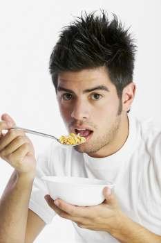 Portrait of a young man eating a bowl of cereal