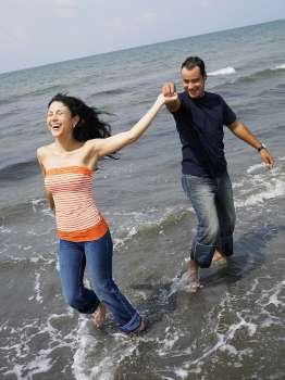 Young couple standing on the beach and smiling