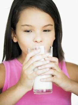 Close-up of a teenage girl holding a glass of milk