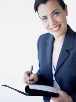 Portrait of a businesswoman smiling and writing on a file