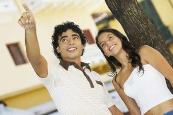 Close-up of a teenage boy pointing to a young woman