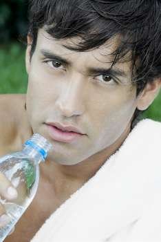Portrait of a young man holding a water bottle