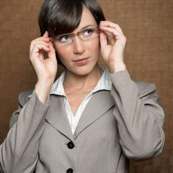 Close-up of a businesswoman adjusting her eyeglasses