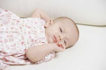 Close-up of a baby girl lying on the bed
