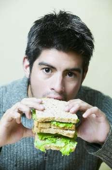 Close-up of a young man eating a sandwich