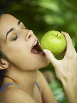 Close-up of a young woman eating an apple