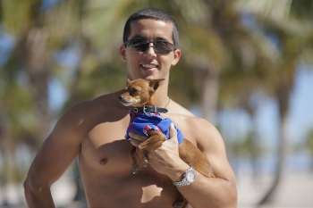 Mid adult man holding a dog and smiling