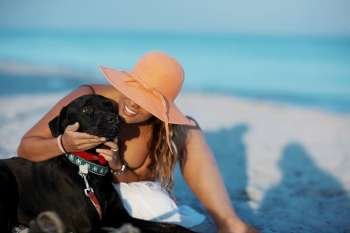 Close-up of a young woman stroking a dog on the beach