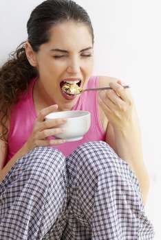 Young woman eating food with a spoon