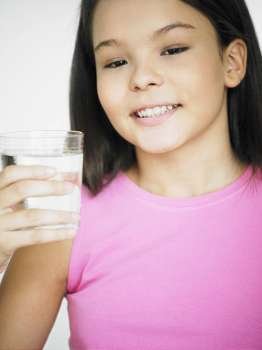 Close-up of a teenage girl holding a glass of water