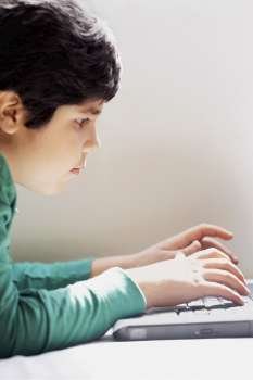 Close-up of a boy using a laptop