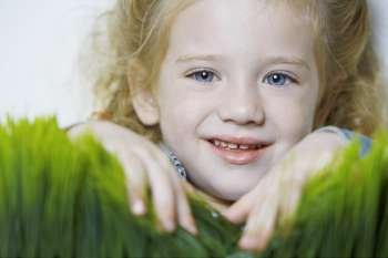 Portrait of a girl smiling over wheatgrass