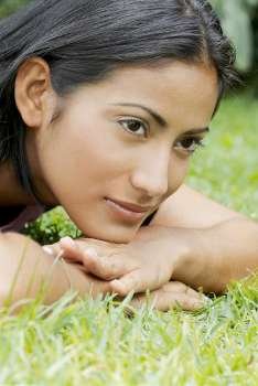Close-up of a young woman lying on the grass