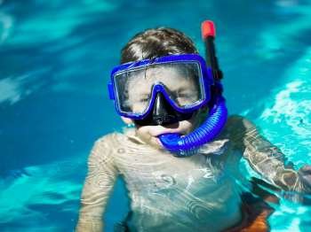 Close-up of a boy wearing a scuba mask in a swimming pool
