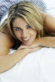 Portrait of a mid adult woman lying on the bed and smiling