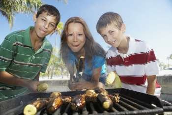 Portrait of a mid adult woman with her children at a barbecue