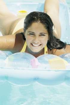Close-up of a teenage girl lying on a pool raft
