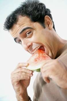 Portrait of a mid adult man eating a slice of watermelon