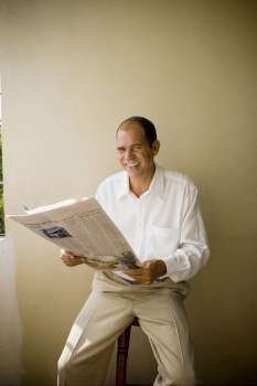 Portrait of a mature man holding a newspaper and smiling