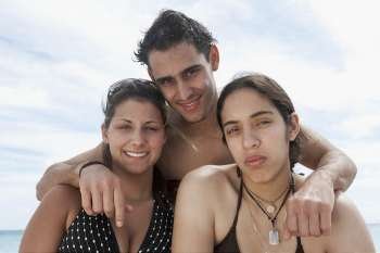 Portrait of two young women and a young man smiling