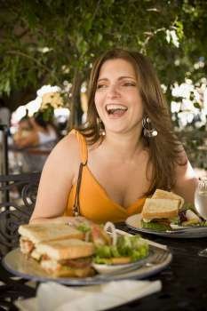 Mid adult woman sitting at a restaurant and laughing, Santo Domingo, Dominican Republic