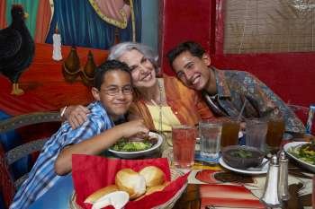 Two boys sitting with their grandmother in a restaurant