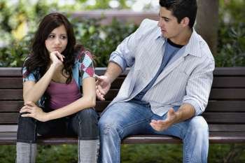 Close-up of a young couple sitting on a park bench