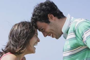 Side profile of a young couple looking at each other and smiling
