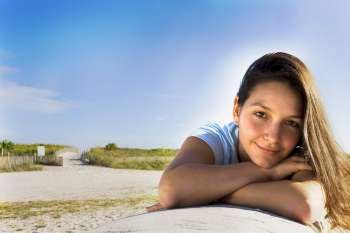Young woman lying on wall at beach