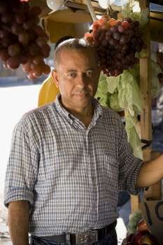 Portrait of a mature man in front of a market stall, Santo Domingo, Dominican Republic