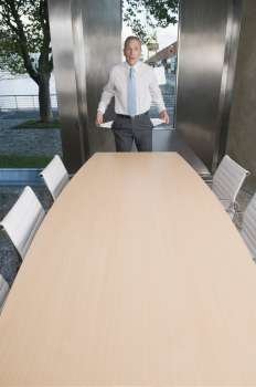 Businessman showing empty pockets in a board room