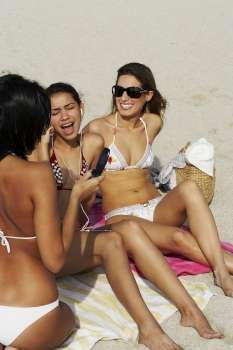 Young women hanging out and sunbathing on beach