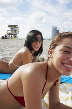 Two friends sunbathing on beach