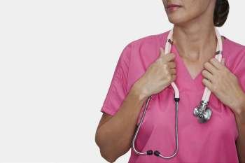 Mid section view of a female nurse holding a stethoscope around her neck