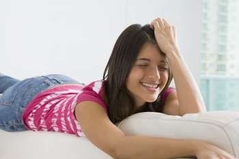 Teenage girl lying on a couch and smiling