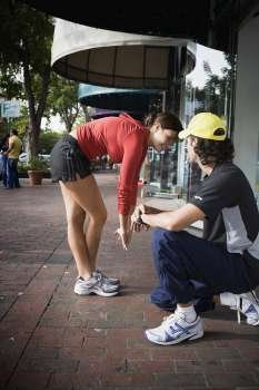 Young woman exercising with physical trainer