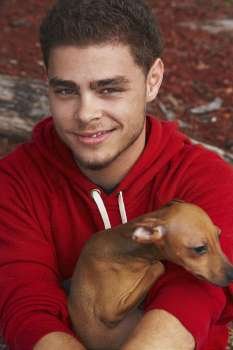 Portrait of a young man smiling with a dog