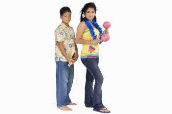 Side profile of a young woman standing with a boy and playing maracas