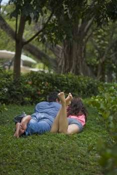 Rear view of a young couple lying in a park