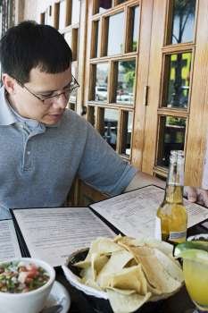 Man reading menu at outdoor restaurant